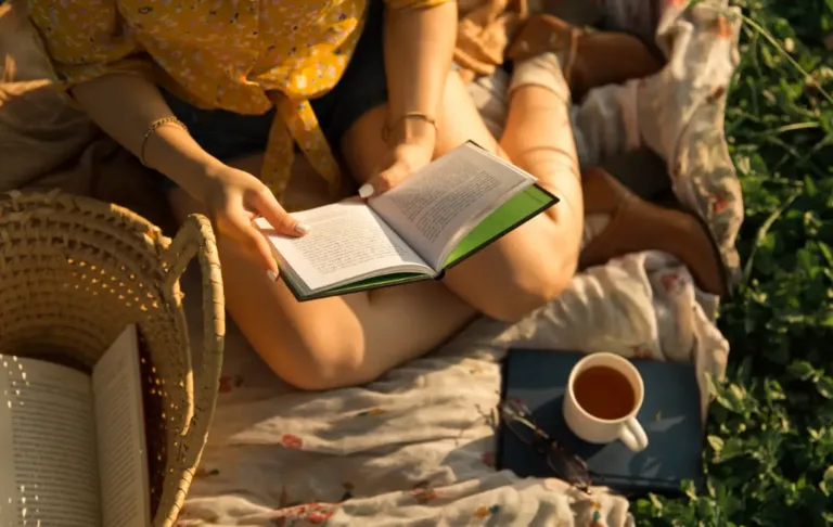 Žena si čte knížku u kávy