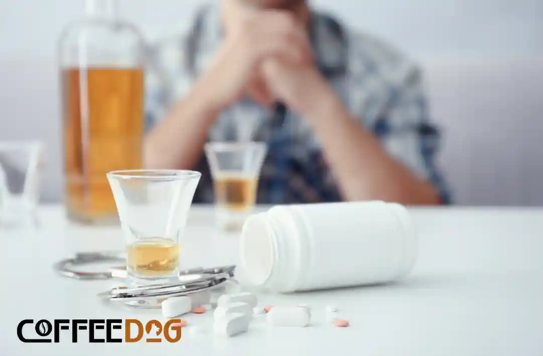 rozházené léky, panák alkoholu a přemýšlející muž v pozadí